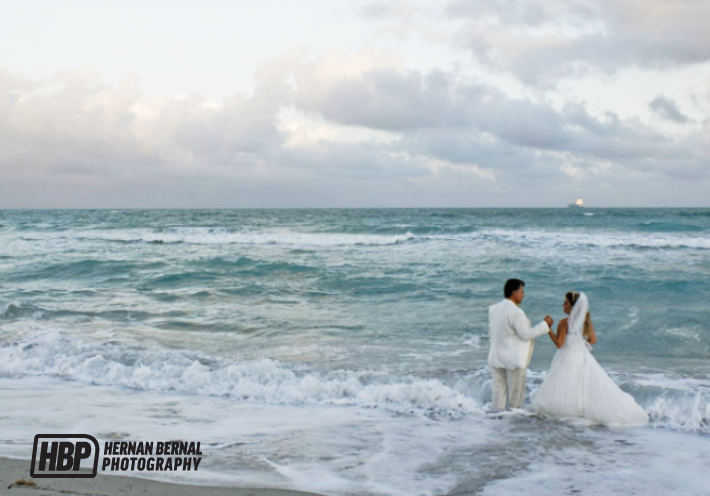 hernan-bernal-photography-fknhard-magazine-beach-wedding-husband-wife-holding-hands-married-couple-crashing-waves-ocean-escape-white-foam-coast-beach-wedding